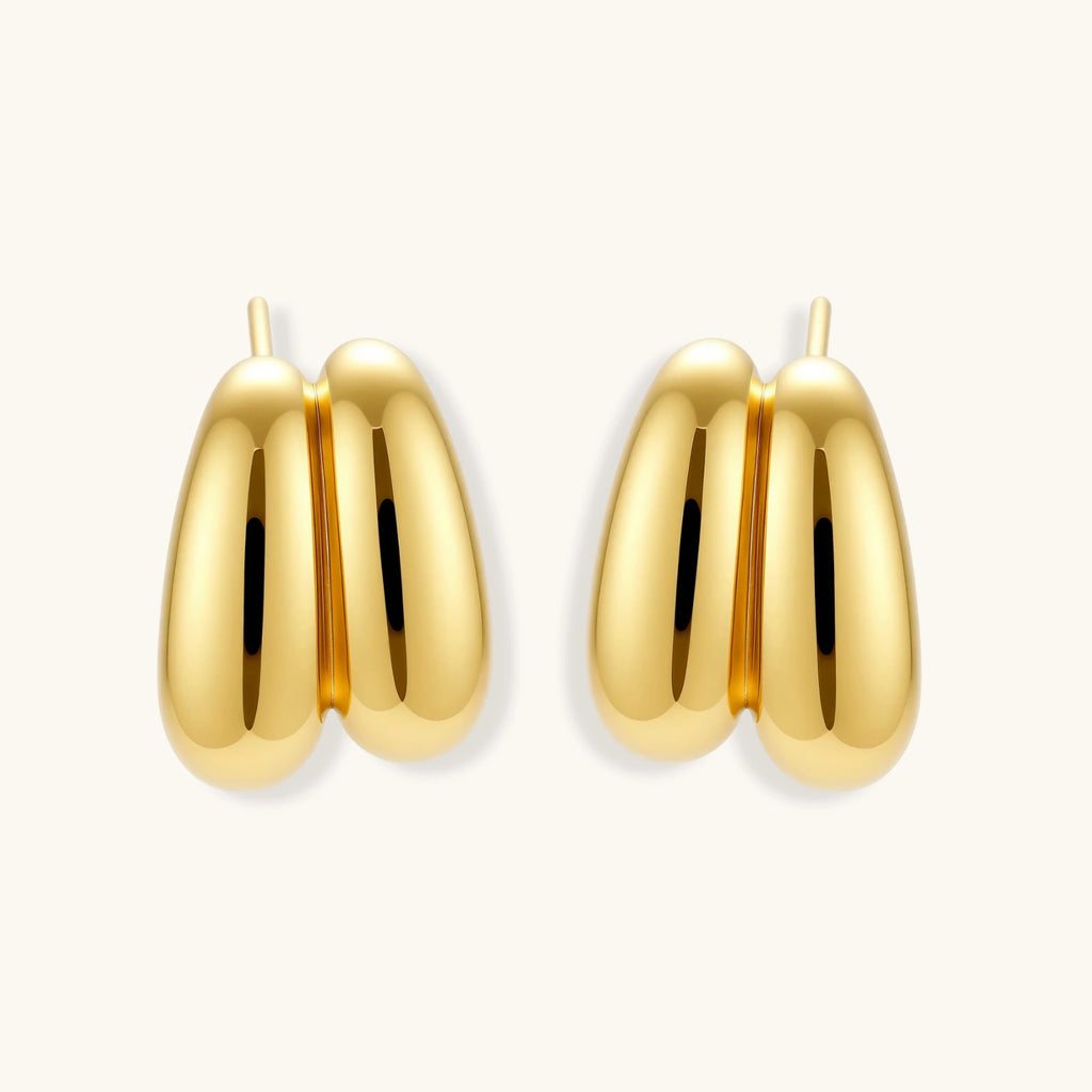 Chunky 18K gold-plated sterling silver hoop earrings with flowing sculptural curves on white background.