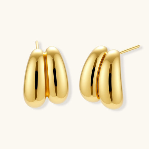 Chunky 18K gold-plated sterling silver hoop earrings with flowing sculptural curves on white background.